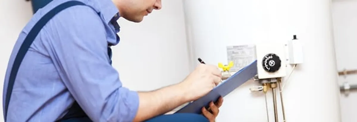 Water heater repair technician inspecting the unit and recording service notes in Des Moines, IA